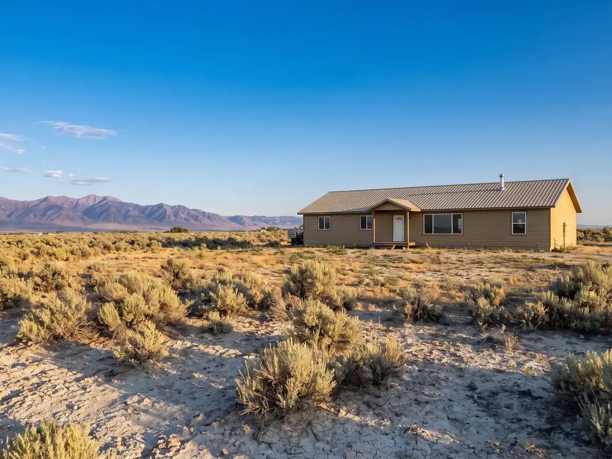 A Mountain Home house in the high desert sagebrush, with the mountains behind